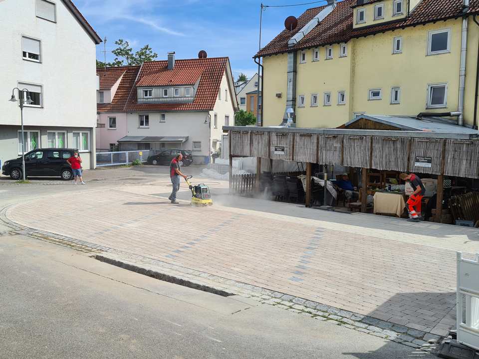 GM-Bau Handwerker verfestigt Pflastersteine mit Rüttelplatte